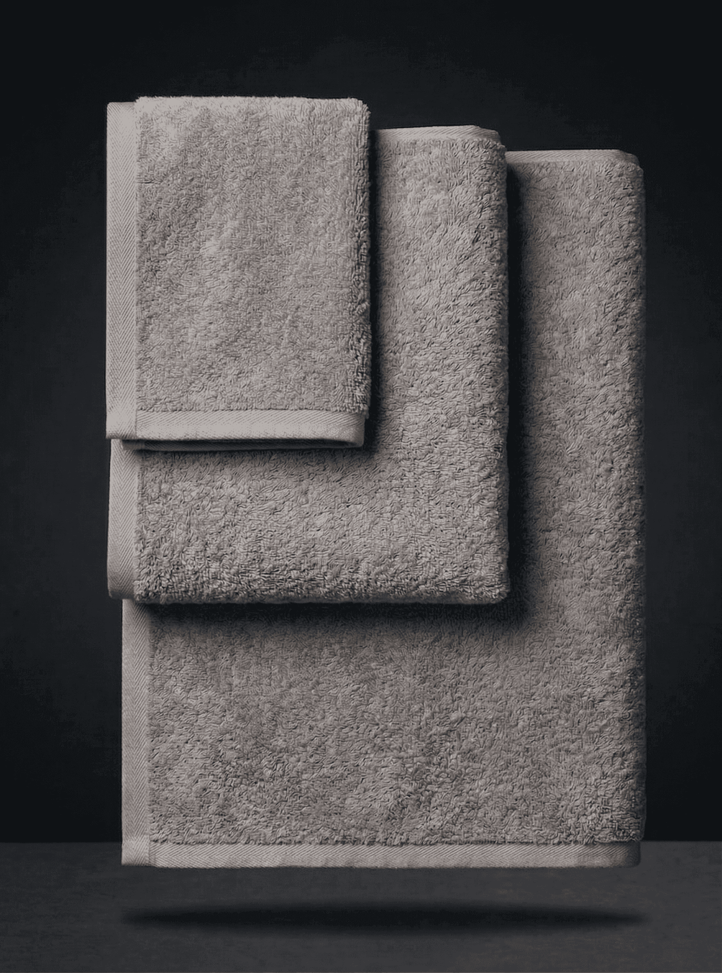 Set of three colorful towels from Sonno Velato, featuring soft, textured gray and vibrant sponge-like fabric for bathroom use.