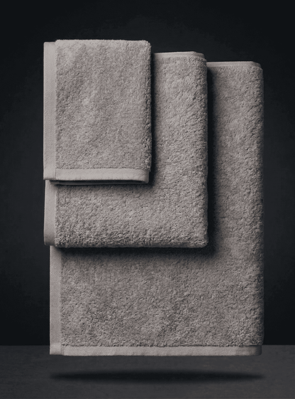 Set of three colorful towels from Sonno Velato, featuring soft, textured gray and vibrant sponge-like fabric for bathroom use.