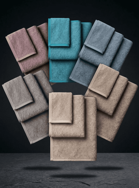 Set of three colorful cotton towels from Sonno Velato's Colored Linea, displayed in a fan shape.